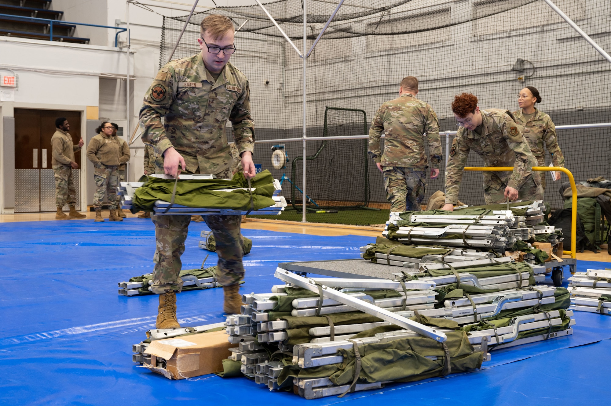 Airmen assigned to the 354th Force Support Squadron unload cots from a cart during Raven Beddown 2024 on Eielson Air Force Base, Alaska, Jan. 6, 2024.