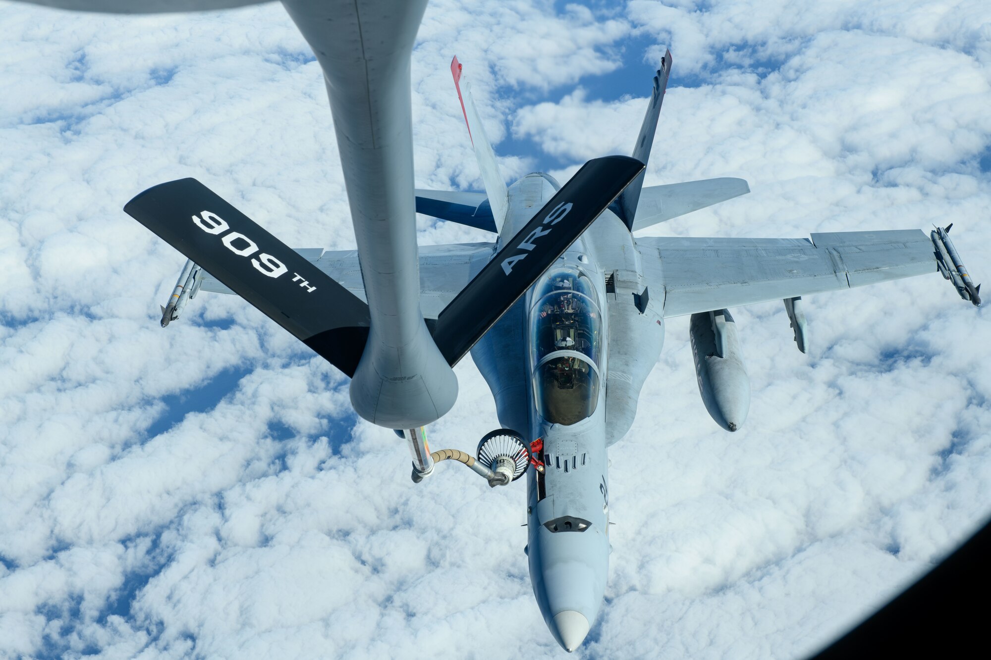 A U.S. Marine Corps F/A-18 Hornet is refueled by a U.S. Air Force KC-135 Stratotanker from Kadena Air Base over the Pacific Jan. 3, 2024. Conducting joint operations enhances the lethality and readiness of U.S. forces and its ability to project superior airpower to the Indo-Pacific region. (U.S. Air Force photo by Senior Airman Cedriue Oldaker)