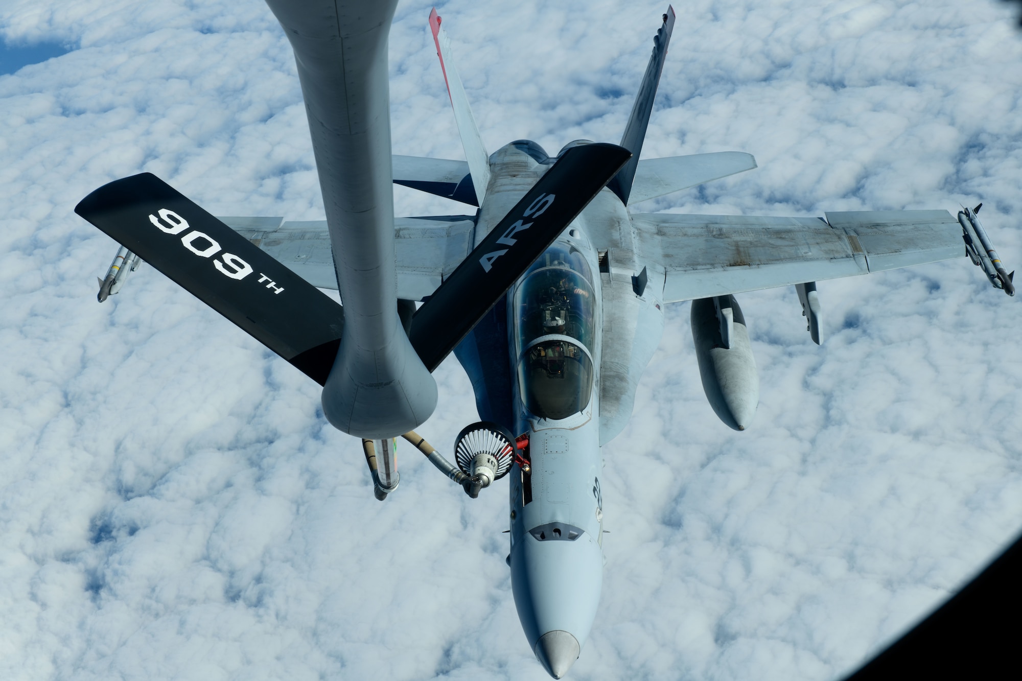 A U.S. Marine Corps F/A-18 Hornet is refueled by a U.S. Air Force KC-135 Stratotanker from Kadena Air Base over the Pacific Jan. 3, 2024. The 909th Air Refueling Squadron conducts joint operations throughout the Indo-Pacific region, demonstrating the critical role mobility forces have in projecting the joint force anywhere, anytime. (U.S. Air Force photo by Senior Airman Cedriue Oldaker)