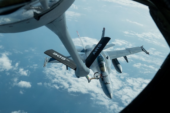 A U.S. Marine Corps F/A-18 Hornet is refueled by a U.S. Air Force KC-135 Stratotanker from Kadena Air Base over the Pacific Jan. 3, 2024. The 909th Air Refueling Squadron conducts joint operations throughout the Indo-Pacific region, demonstrating the critical role mobility forces have in projecting the joint force anywhere, anytime. (U.S. Air Force photo by Senior Airman Cedriue Oldaker)