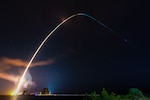 A rocket soars into the night sky.