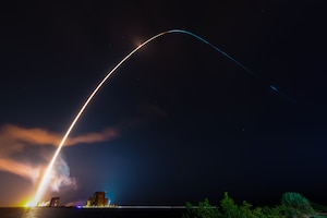 A rocket soars into the night sky.