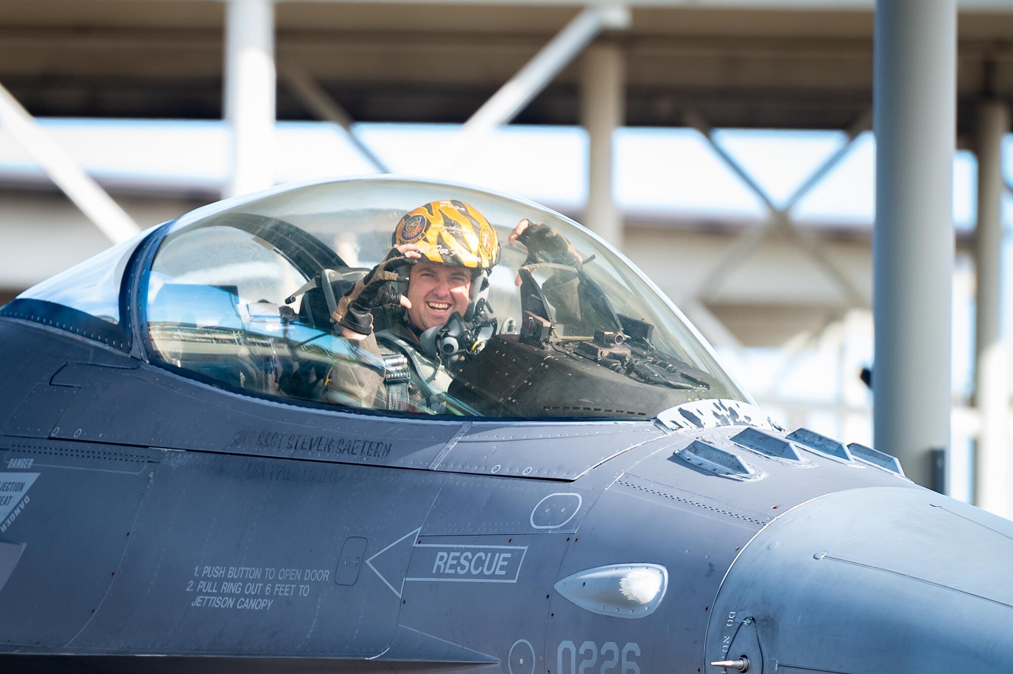 A pilot displays his squadron hand signals before takeoff.