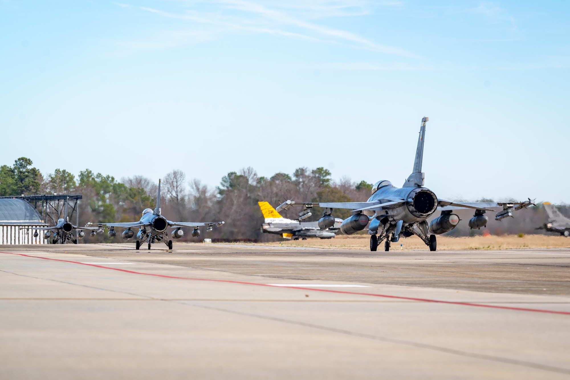 F-16 Fighting Falcons taxi on the runway.