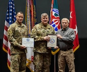 Soldiers present award to a man.