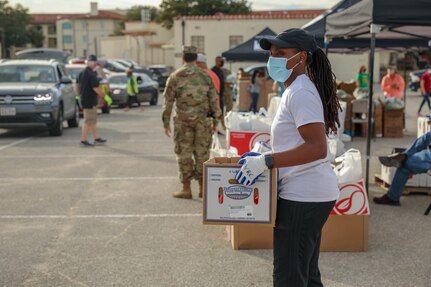 Person holding box of food.