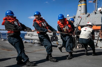 Sailors aboard Arleigh Burke-class guided-missile destroyer USS Sterett (DDG 104) heave a messenger line during a replenishment-at-sea with Military Sealift Command fleet replenishment oiler USNS John Ericsson (T-AO 194).