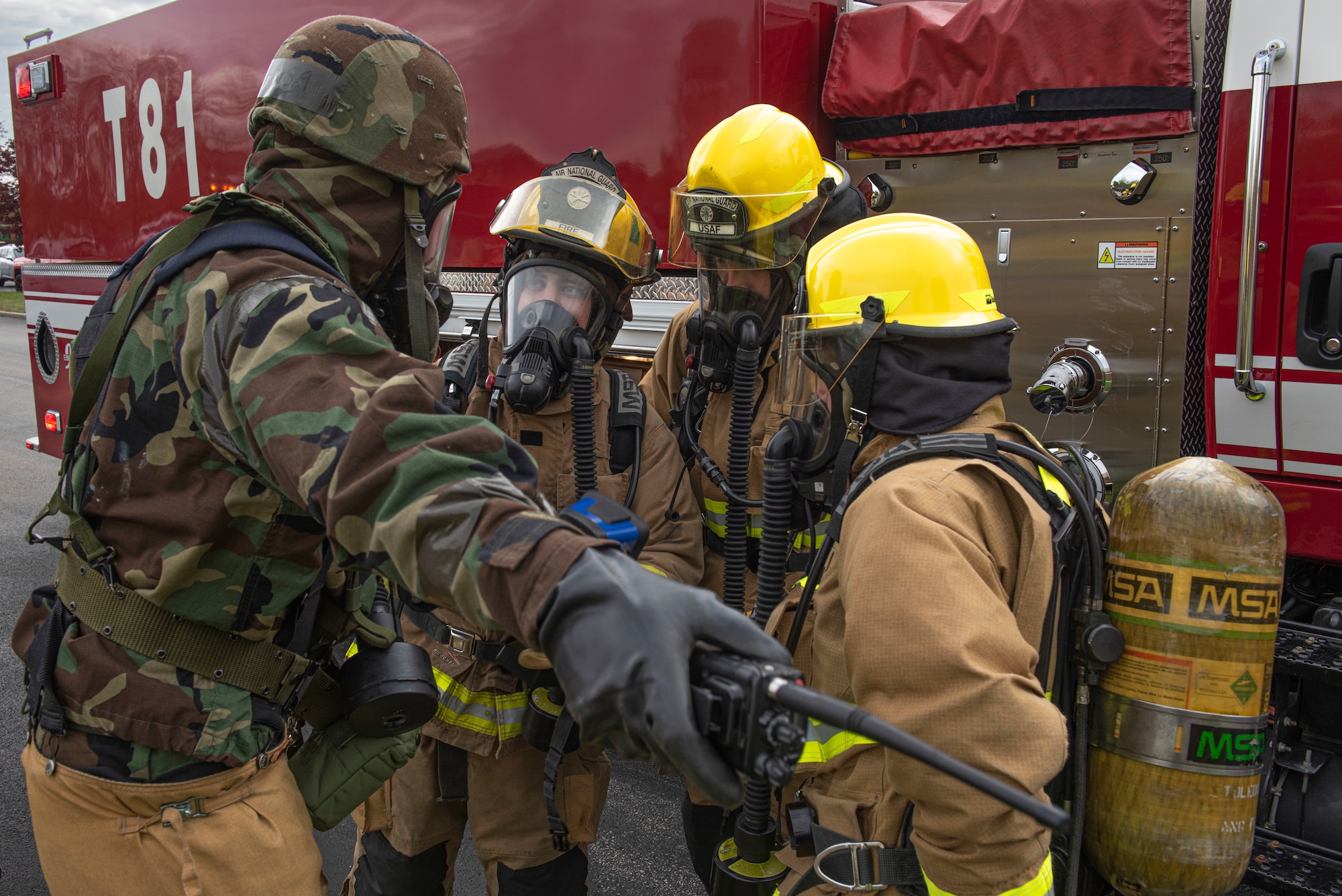 Firefighters huddle together to talk during a training session.