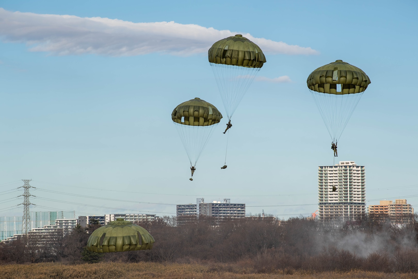 Japan Ground Self-Defense Force paratroopers from the 1st Airborne Brigade descend to a drop zone during the annual New Year's Jump exhibition at Camp Narashino, Japan, Jan. 7, 2024. The New Year's Jump not only brought together U.S. and Japanese forces, but also created a platform for international allies and partners to collaborate. (U.S. Air Force photo by Airman 1st Class Natalie Doan)