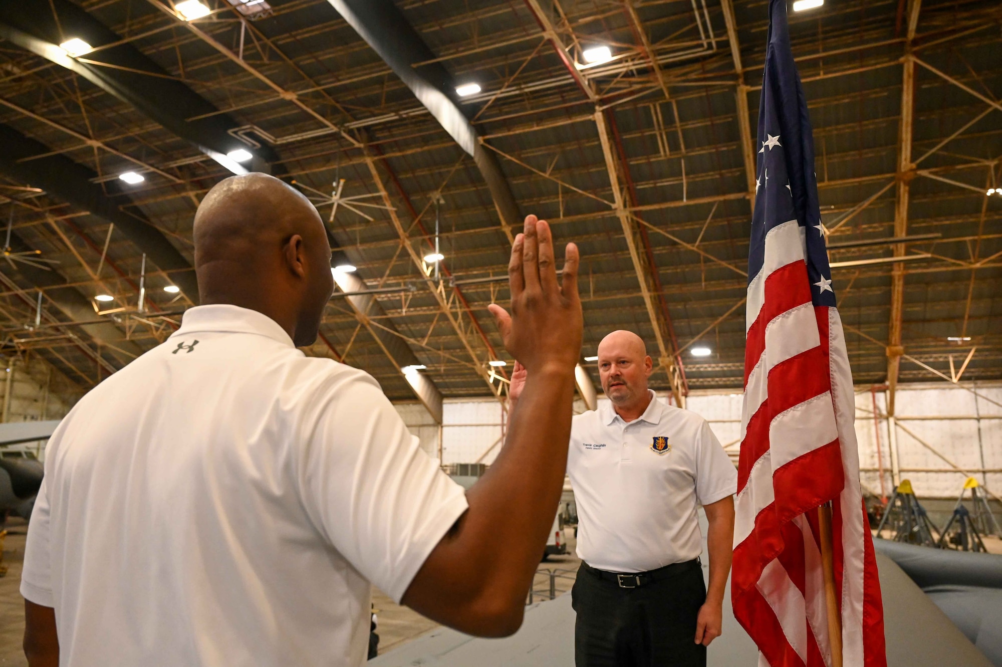 Travis Coughlin, right, 97th Maintenance Group deputy director, administers the oath of enlistment to Jimmel Winkfield, 97th Aircraft Maintenance Squadron (AMXS) deputy director, at Altus Air Force Base, Oklahoma, Dec. 28, 2023. Winkfield has worked in the AMXS since 2017. (U.S. photo by Airman 1st Class Kari Degraffenreed)