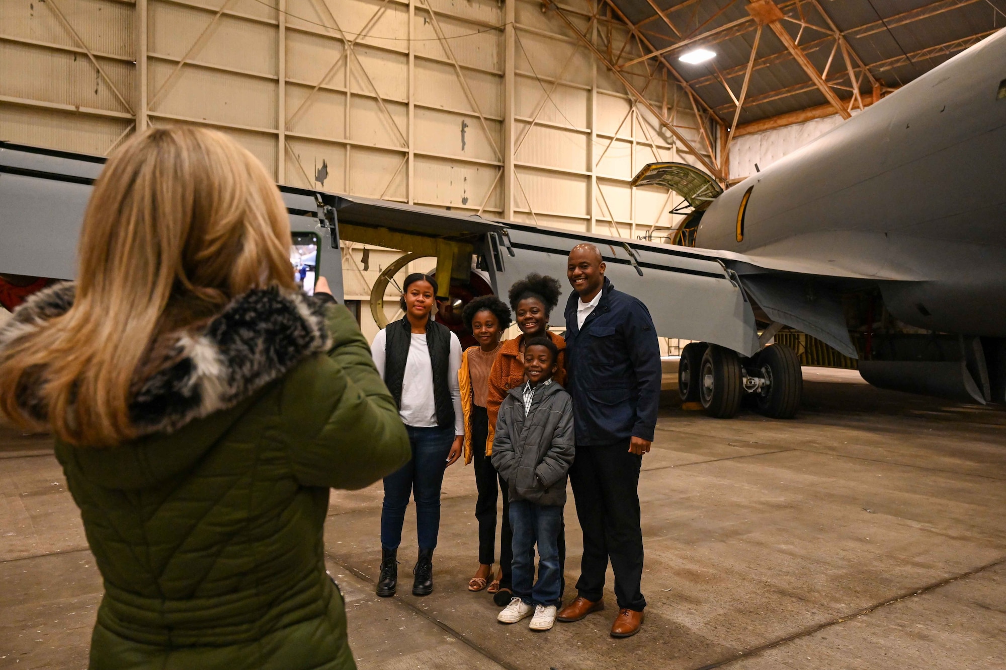 Jimmel Winkfield, 97th Aircraft Maintenance Squadron deputy director, poses with his children after being administered the oath of enlistment at Altus Air Force Base (AFB), Oklahoma, Dec. 28, 2023. Winkfield spent six years in active-duty service with the Air Force before working as a civilian at Altus AFB. (U.S. Air Force photo by Airman 1st Class Kari Degraffenreed)