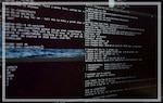 A photo of a black computer screen with code or some sort of text shown.