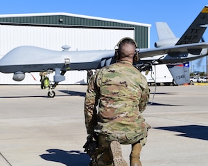 A Texas Air National Guard member of the 147th Attack Wing Aircraft Maintenance Squadron watches as an MQ-9 Reaper prepares to taxi at Scholes International Airport in Galveston, Texas, Jan. 10, 2024. The wing tested satellite launch and recovery operations as part of its approach to the Agile Combat Employment concept.