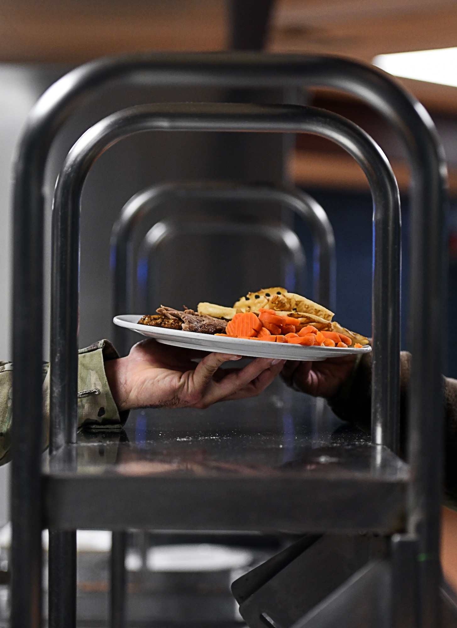 A plate of food is handed off at the dining facility over the countertop.