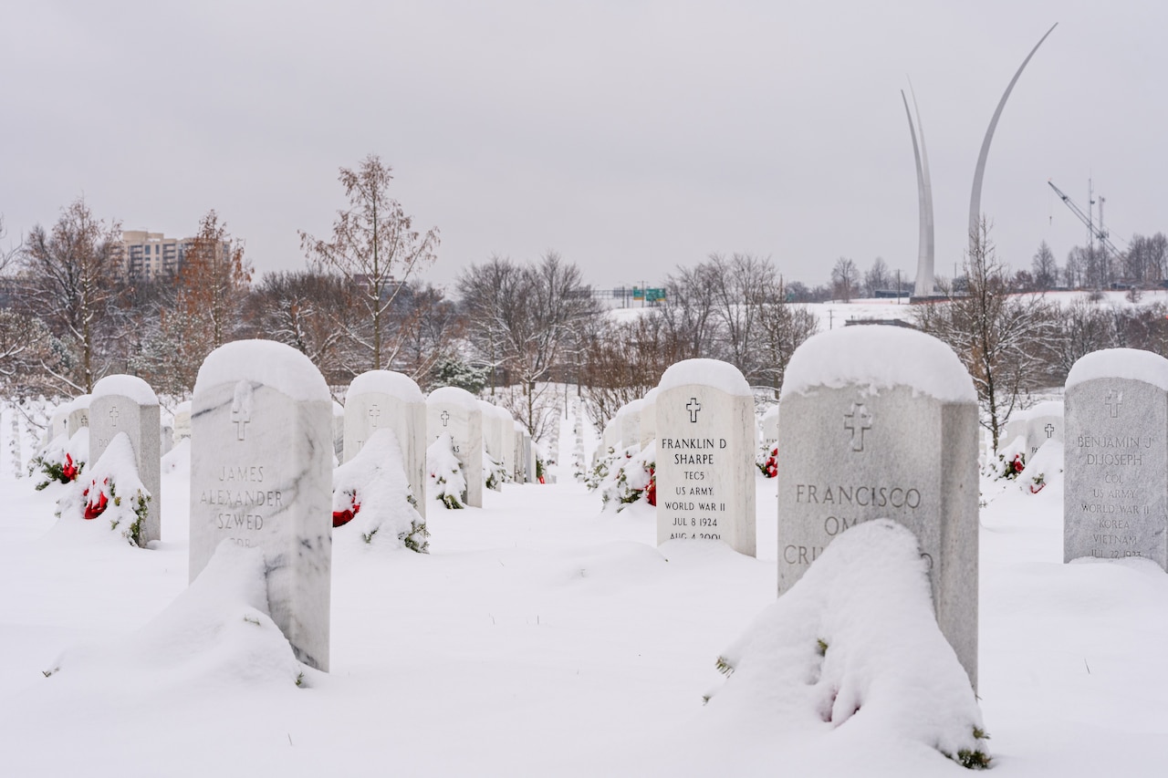 Snow covers gravestones at Arlington National Cemetery.