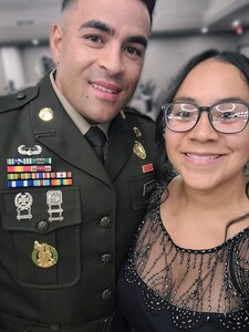 Male Soldier in a U.S. Army dress uniform poses in a selfie with female in a black formal dress