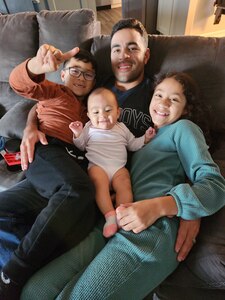 Man sits on couch with his two sons and daughter