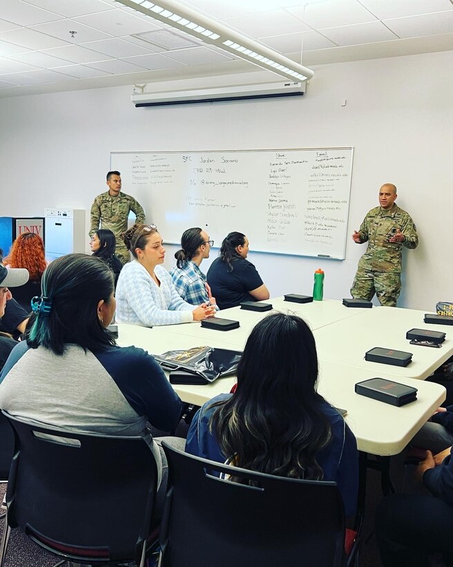 Two male U.S. Army Soldiers in uniform give a lecture to a class