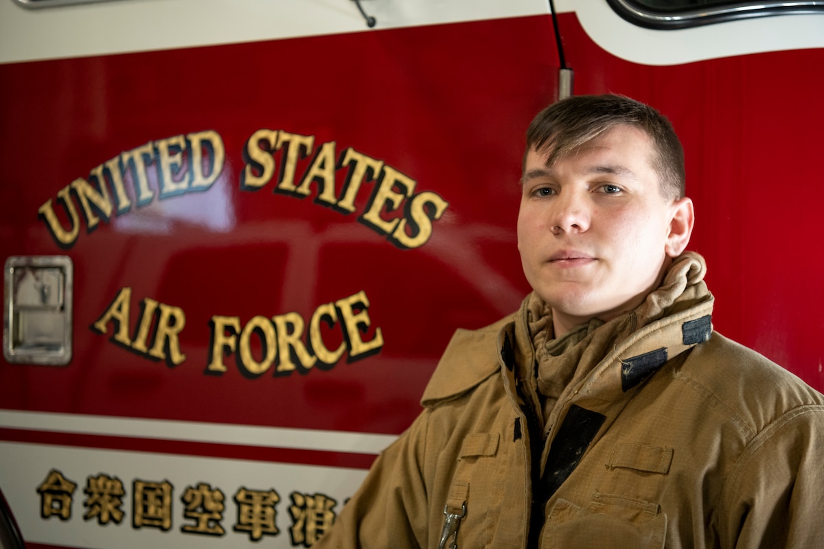 U.S. Air Force Senior Airman Ethan Embrey, 35th Civil Engineer Squadron firefighter poses in front of a Fire Engine at Misawa Air Base, Japan, Jan. 16, 2024.