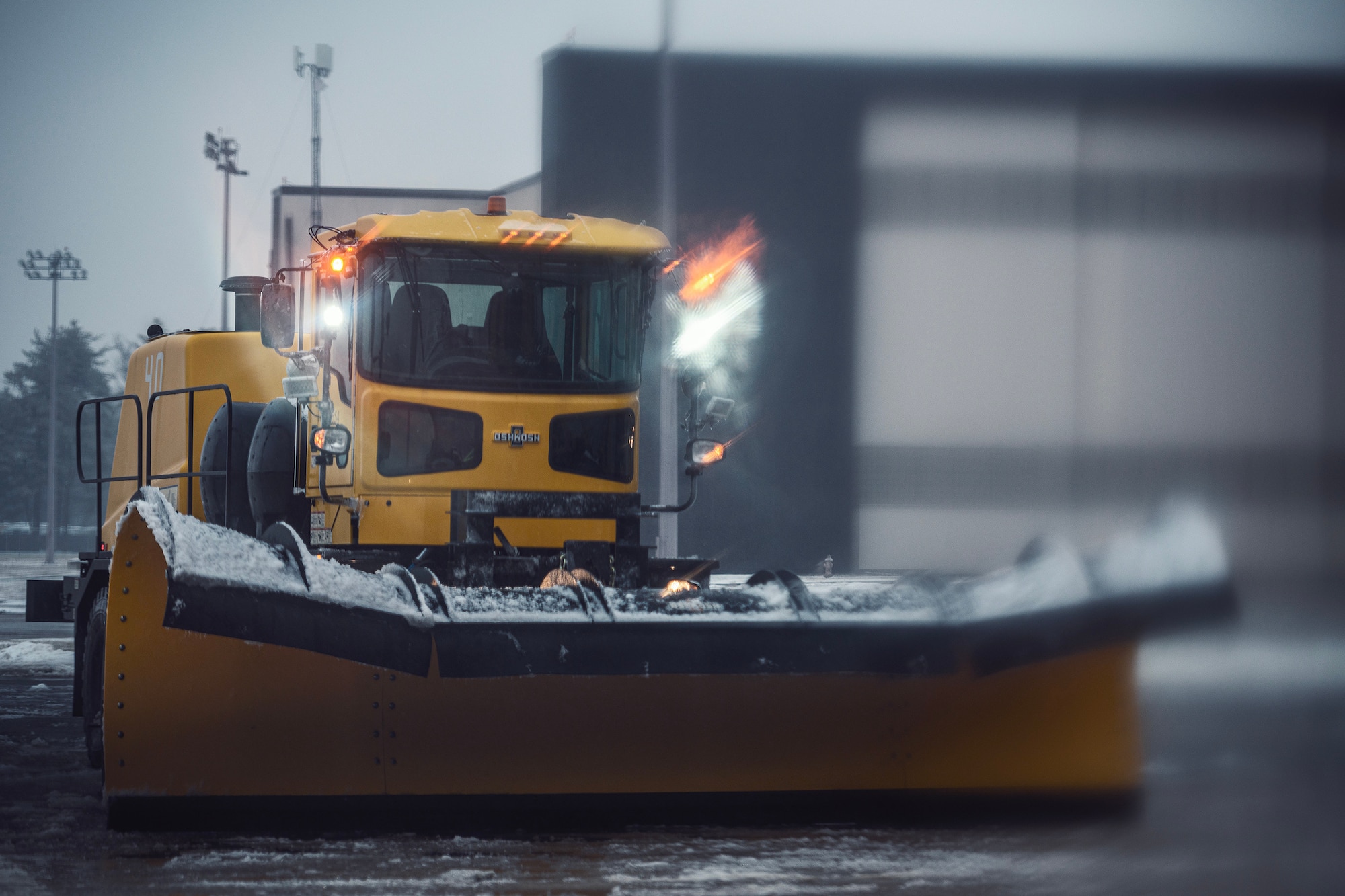 A snow-removal vehicle clears the flightline of snow during a winter storm at Joint Base McGuire-Dix-Lakehurst, N.J., Jan. 16, 2024. Airmen assigned to various JB MDL squadrons maneuvered through harsh conditions to keep the mission going despite several base closures due to safety concerns. (U.S. Air Force photo by Staff Sgt. Austin Knox)