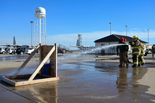 Honorary commanders spray a target with a fire hose during the 17th Training Group immersion at the Louis F. Garland Department of the Defense Fire Academy, Goodfellow Air Force Base, Texas, Jan. 12, 2024. Each honorary commander tried their hand at tasks students are expected to be proficient in before they leave the 312th Training Squadron. (U.S. Air Force photo by Airman 1st Class Madison Collier)
