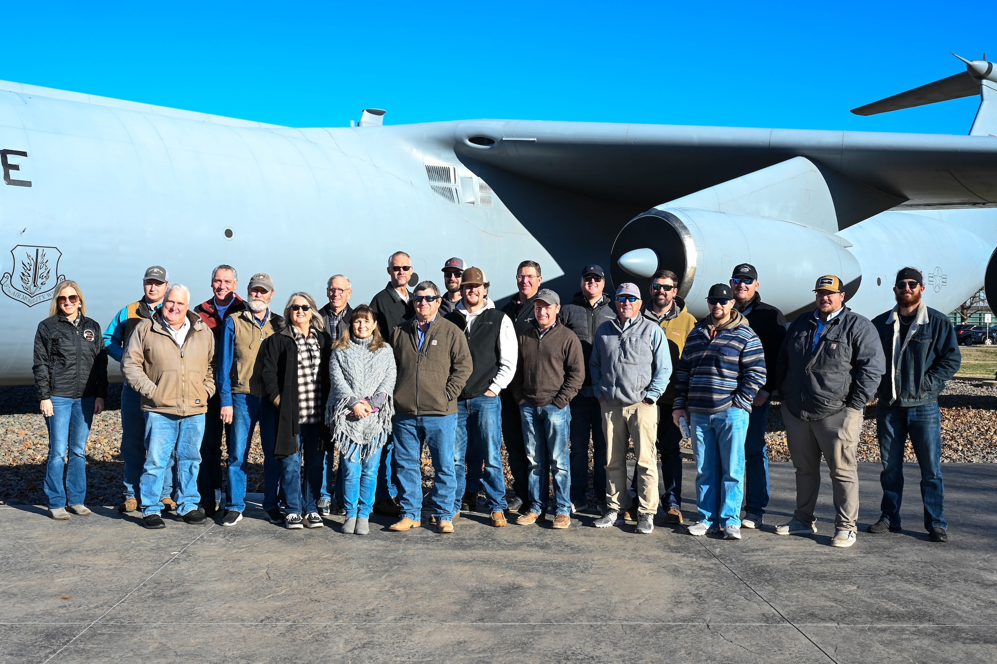 Members of the Altus agricultural and farming community pose for a group photo during the Airpower and Agricultural: Base Tour at Altus Air Force Base, Oklahoma, Jan. 12, 2024. The tour gave local members of the agriculture community the opportunity to witness the mission of the 97th Air Mobility Wing. (U.S. Air Force photo by Airman First Class Heidi Bucins)