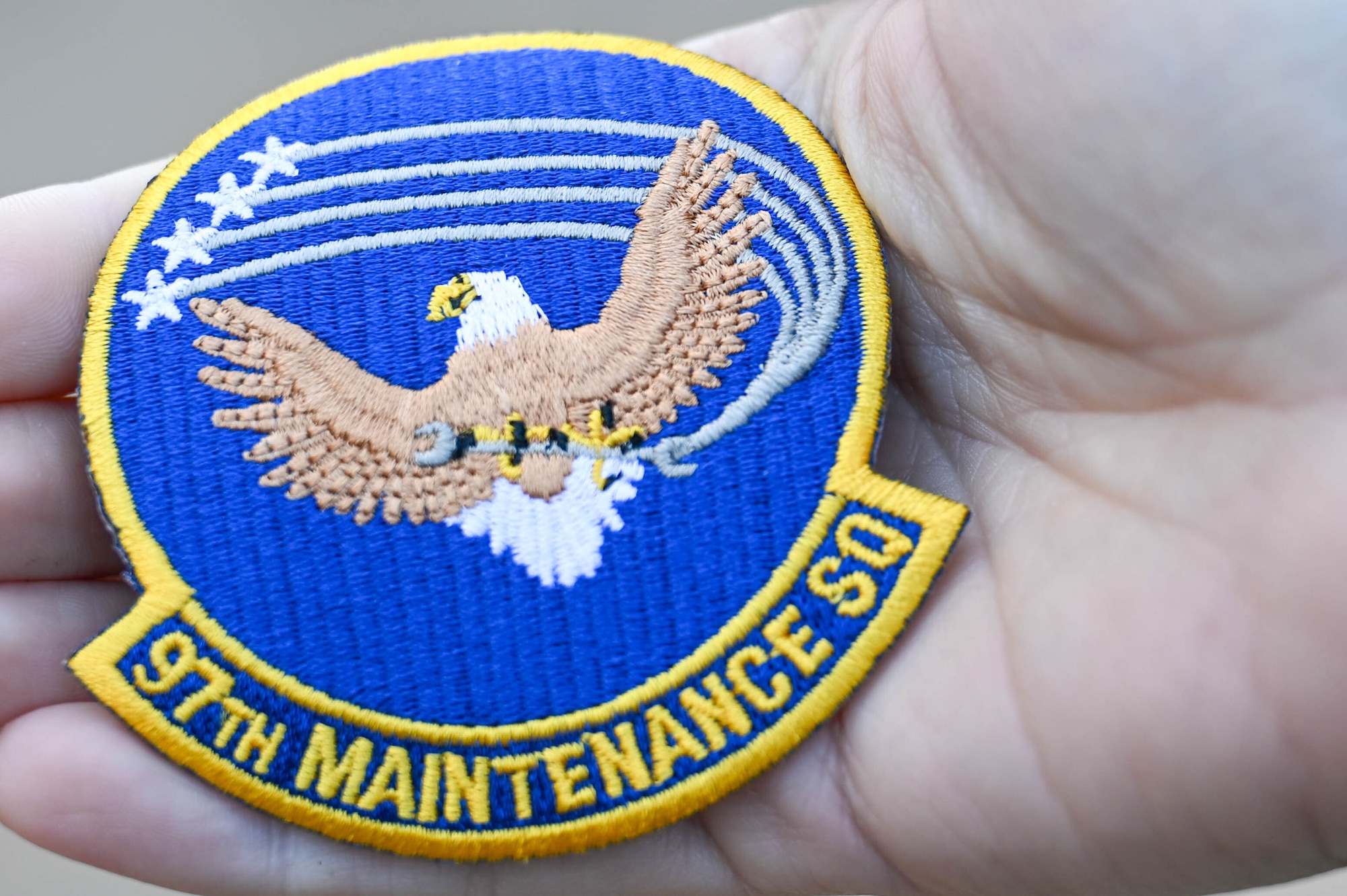 Nicole Valence, 97th Air Mobility Wing commander secretary holds a 97th Maintenance Squadron patch during the Airpower and Agriculture: Base Tour at Altus Air Force Base, Oklahoma, Jan 12, 2024. The patches were given out to Altus agricultural community members attending the event. (U.S. Air Force photo by Airman First Class Heidi Bucins)