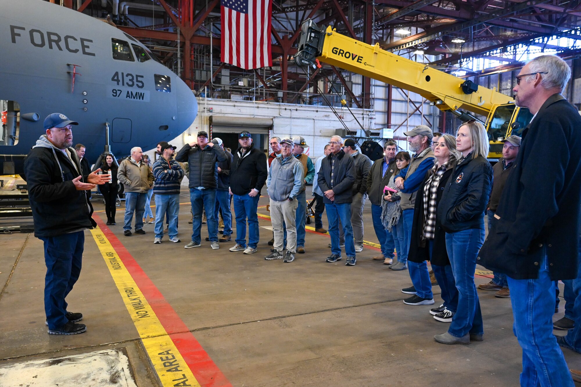 Timothy Keck (left), 97th Aircraft Maintenance Squadron (AMXS) flight inspection chief, welcomes members of the agricultural community to the 97th AMXS during the Airpower and Agriculture: Base Tour at Altus Air Force Base, Oklahoma, Jan. 12, 2024. Attendees were able to see the inside of a KC-135 Stratotanker and a C-17 Globemaster III. (U.S. Air Force photo by Airman First Class Heidi Bucins)