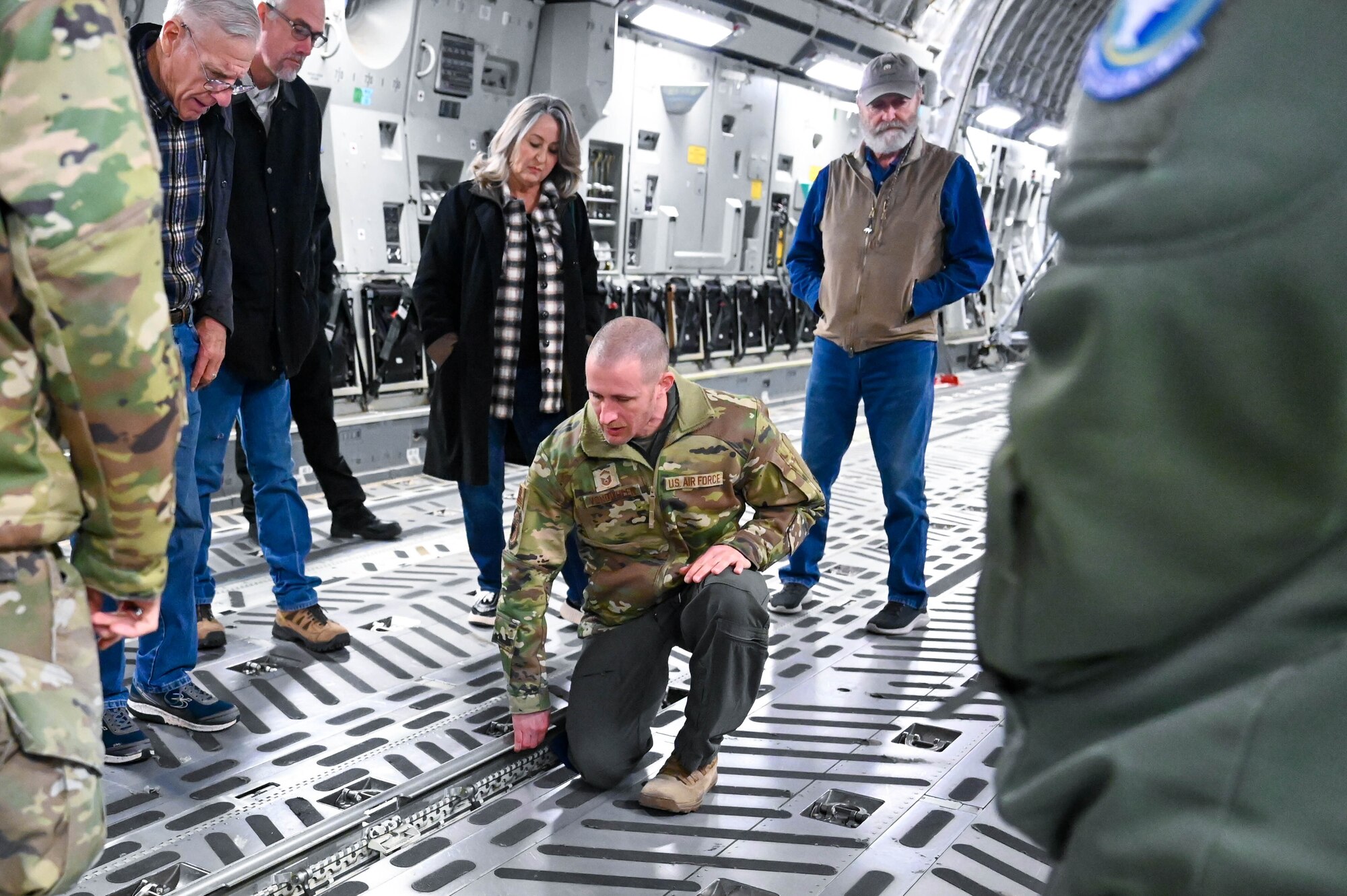 U.S. Air Force Senior Master Sgt. Joseph Vondohlen (middle), 56th Air Refueling Squadron senior enlisted leader, shows members of the Altus agricultural community the inside of a C-17 Globemaster III during the Airpower and Agriculture: Base Tour at Altus Air Force Base, Oklahoma, Jan. 12, 2024. Attendees were able to learn how the aircraft supports strategic transport of cargo and troops. (U.S. Air Force photo by Airman First Class Heidi Bucins)