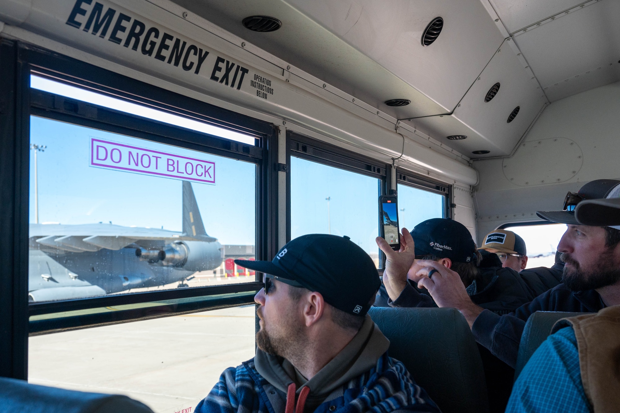 Members of the local Altus agricultural and farming community watch a C-17 Globemaster III taxi on the flightline during the Airpower and Agriculture: Base Tour at Altus Air Force Base, Oklahoma, Jan 12, 2024. The tour was held to give the agricultural partners a chance to see the day-to-day operations on base. (U.S. Air Force photo by Airman First Class Heidi Bucins)