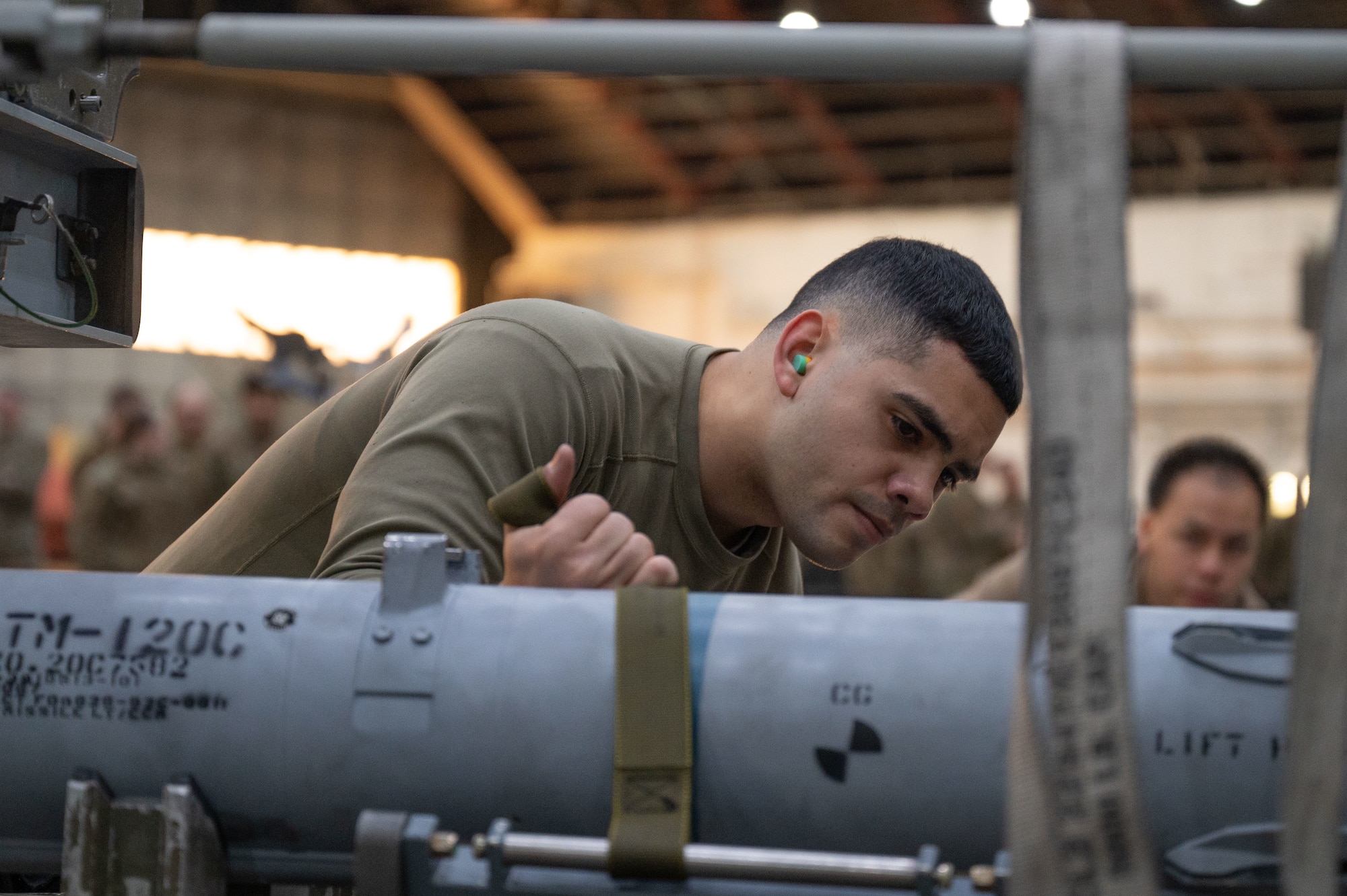 U.S. Air Force Staff Sgt. Justin Duran, 355th Fighter Generation Squadron load crew team chief, pulls straps on munitions during a load competition on Eielson Air Force Base, Alaska, Jan. 11, 2024.