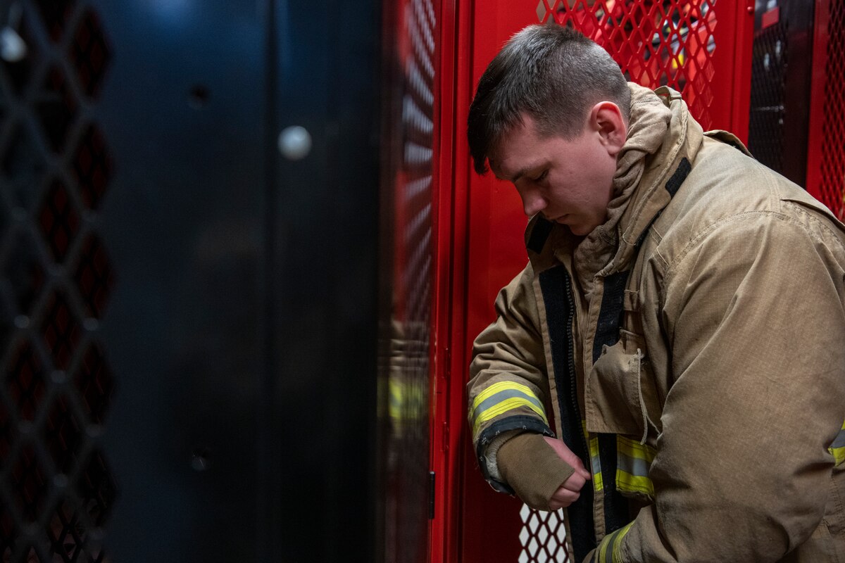 U.S. Air Force Senior Airman Ethan Embrey, 35th Civil Engineer Squadron firefighter, dons his firefighting jacket at Misawa Air Base, Japan, Jan. 16, 2024.