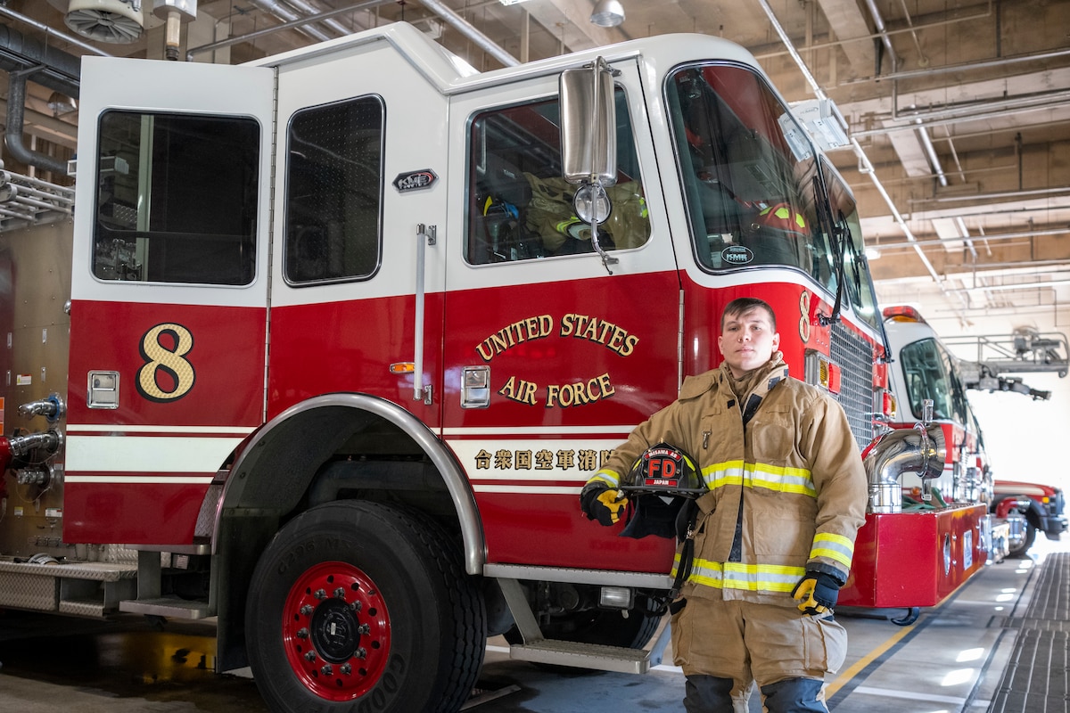 U.S. Air Force Senior Airman Ethan Embrey, 35th Civil Engineer Squadron firefighter, poses in front of a Fire Engine at Misawa Air Base, Japan, Jan. 16, 2024.