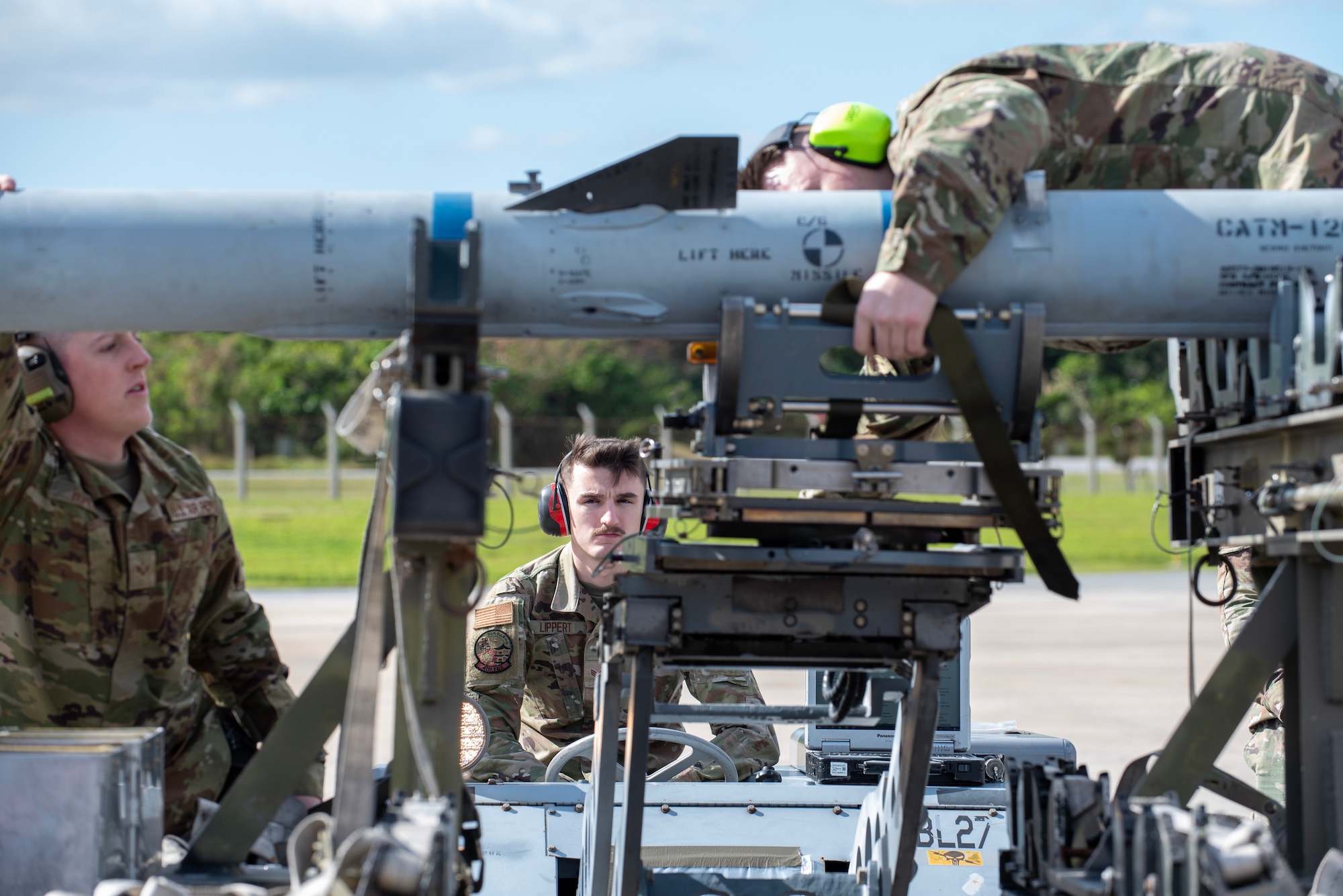 three airmen work together for a munitions load competition