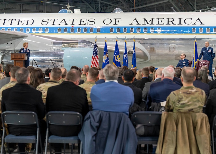 Individuals on stage in front of an USAF plane.