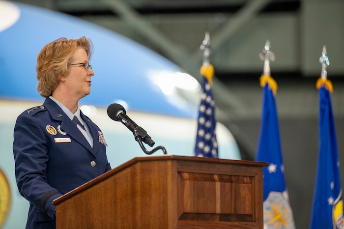 Woman gives speech behind podium.