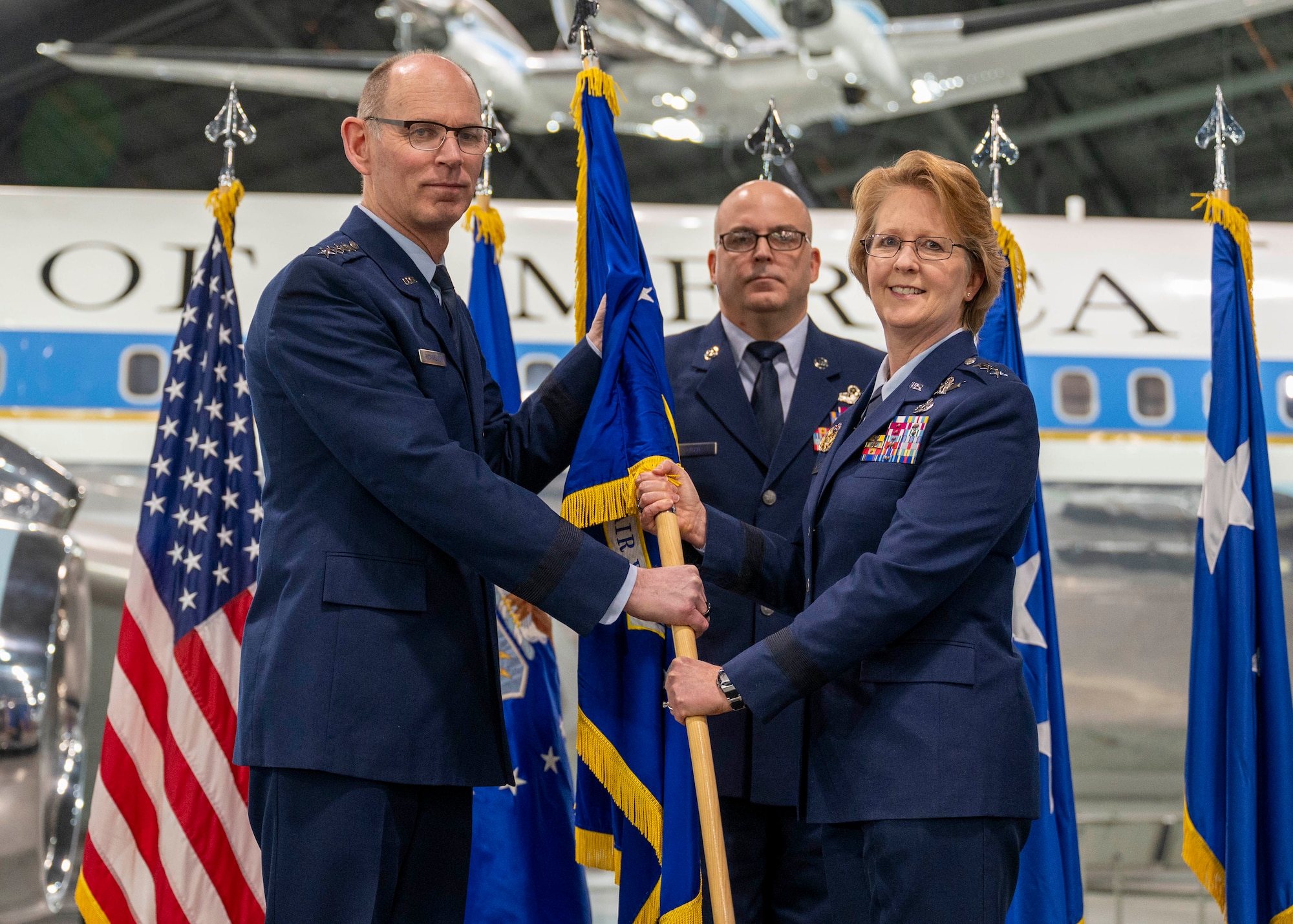 Gen. Duke Richardson, Air Force Materiel Command commander, passes the guidon over to Lt. Gen. Donna Shipton, Air Force Life Cycle Management Center commander, during an Assumption of Command ceremony at the National Museum of the Air Force in Dayton, Ohio, Jan. 17, 2024.