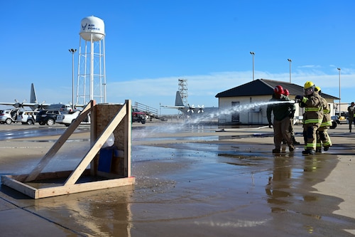 Honorary commanders spray a target with a fire hose during the 17th Training Group immersion at the Louis F. Garland Department of the Defense Fire Academy, Goodfellow Air Force Base, Texas, Jan. 12, 2024. Each honorary commander tried their hand at tasks students are expected to be proficient in before they leave the 312th Training Squadron. (U.S. Air Force photo by Airman 1st Class Madison Collier)