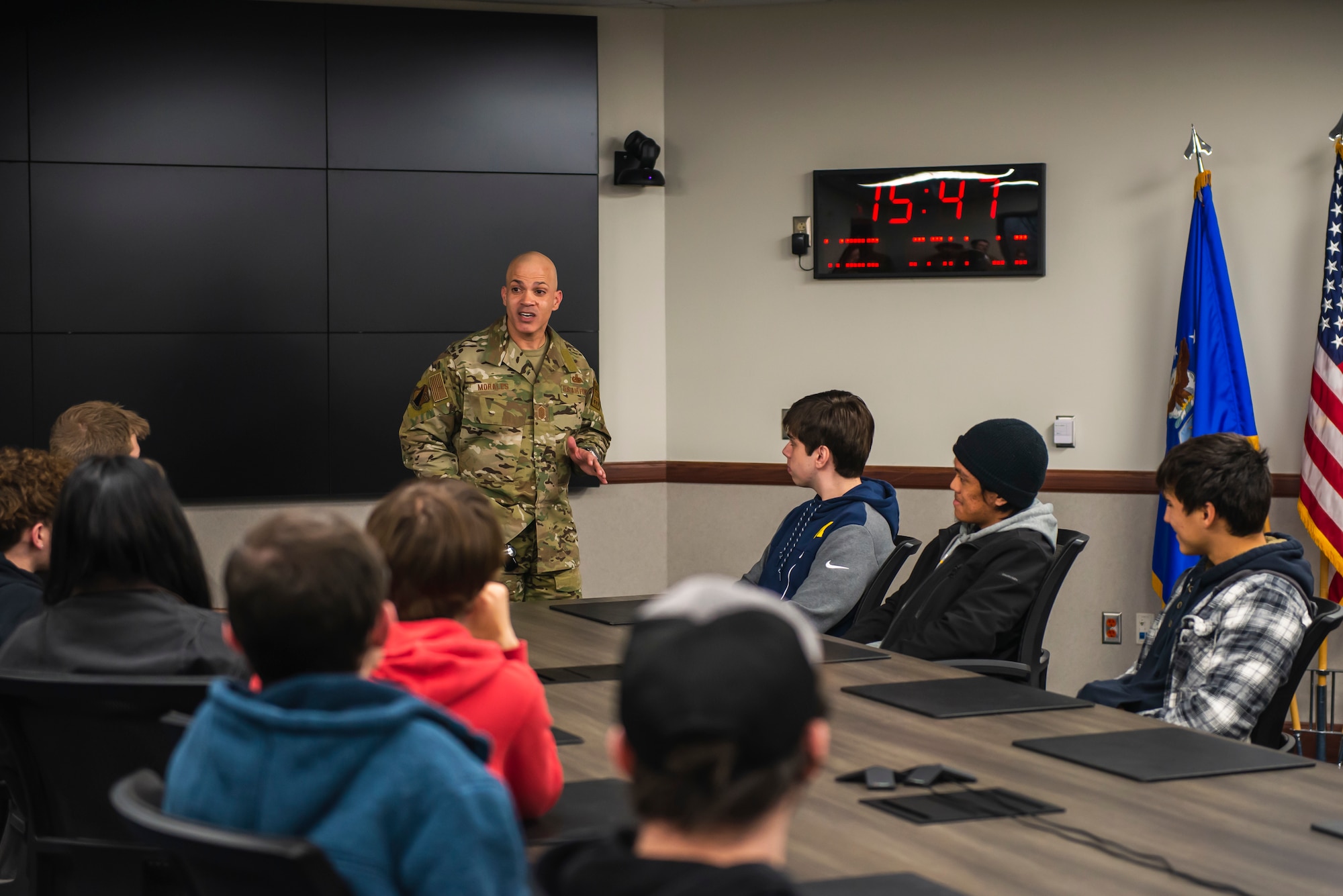 Command Chief sits at the front of a conference room table with young people sitting and listening