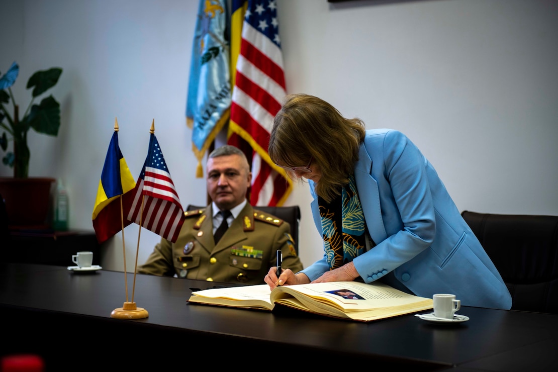 NAVAL SUPPORT FACILITY (NSF) DEVESELU, ROMANIA –– Kathleen Kavalec, American ambassador to Romania, signs the distinguished guest log at Baza Militară 99 Deveselu, February 28, 2023. Navy Region EURAFCENT oversees nine installations in seven countries, enabling U.S., allied and partner nation forces to be where they are needed, when they are needed, in order to ensure security and stability in the European, African, and Central Command areas of responsibility. (U.S. Navy photo by Mass Communication Specialist 2nd Class Haydn N. Smith)