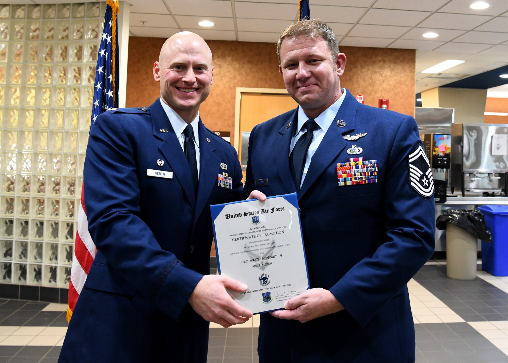 U.S. Air Force Major Devery Herth, the 106th Force Support Squadron commander of the 106th Rescue Wing, F.S. Gabreski Air National Guard Base, Westhampton Beach, New York Air National Guard, promotes U.S. Air Force Senior Master Sgt. Neil Allison, the 106th Force Support Squadron senior enlisted leader to Chief Master Sergeant, at a ceremony on base, November 4, 2023.