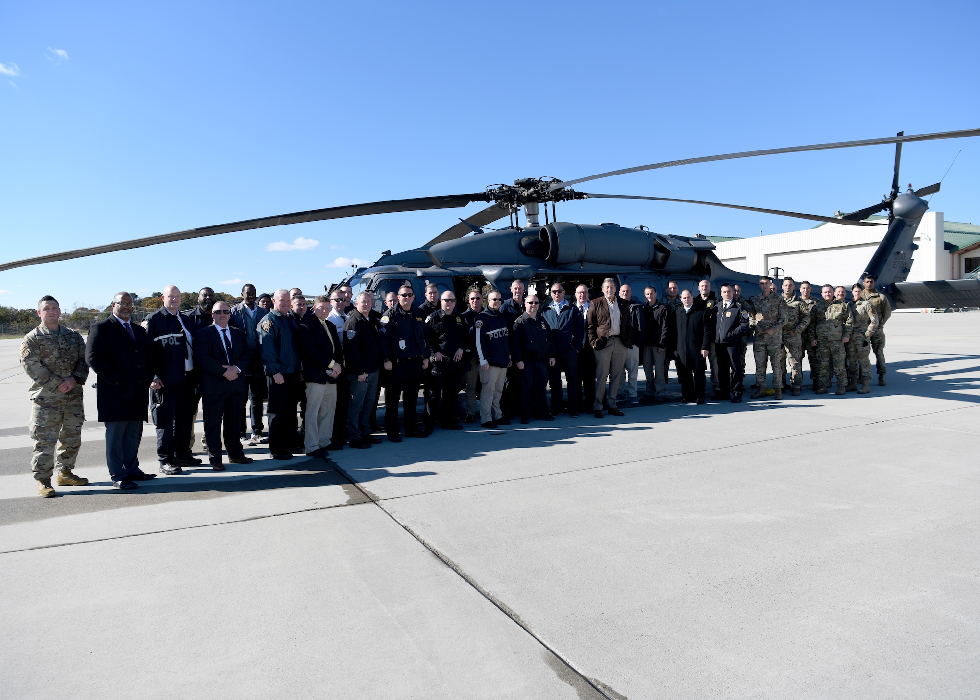 Thirty local, state, and federal law enforcement personnel and Airmen of the 106th Rescue Wing, Francis S. Gabreski Air National Guard Base, Westhampton Beach, New York Air National Guard, stand next to an HH-60G Pavehawk rescue helicopter at a Law Enforcement Orientation Day event on base, November 2, 2023.