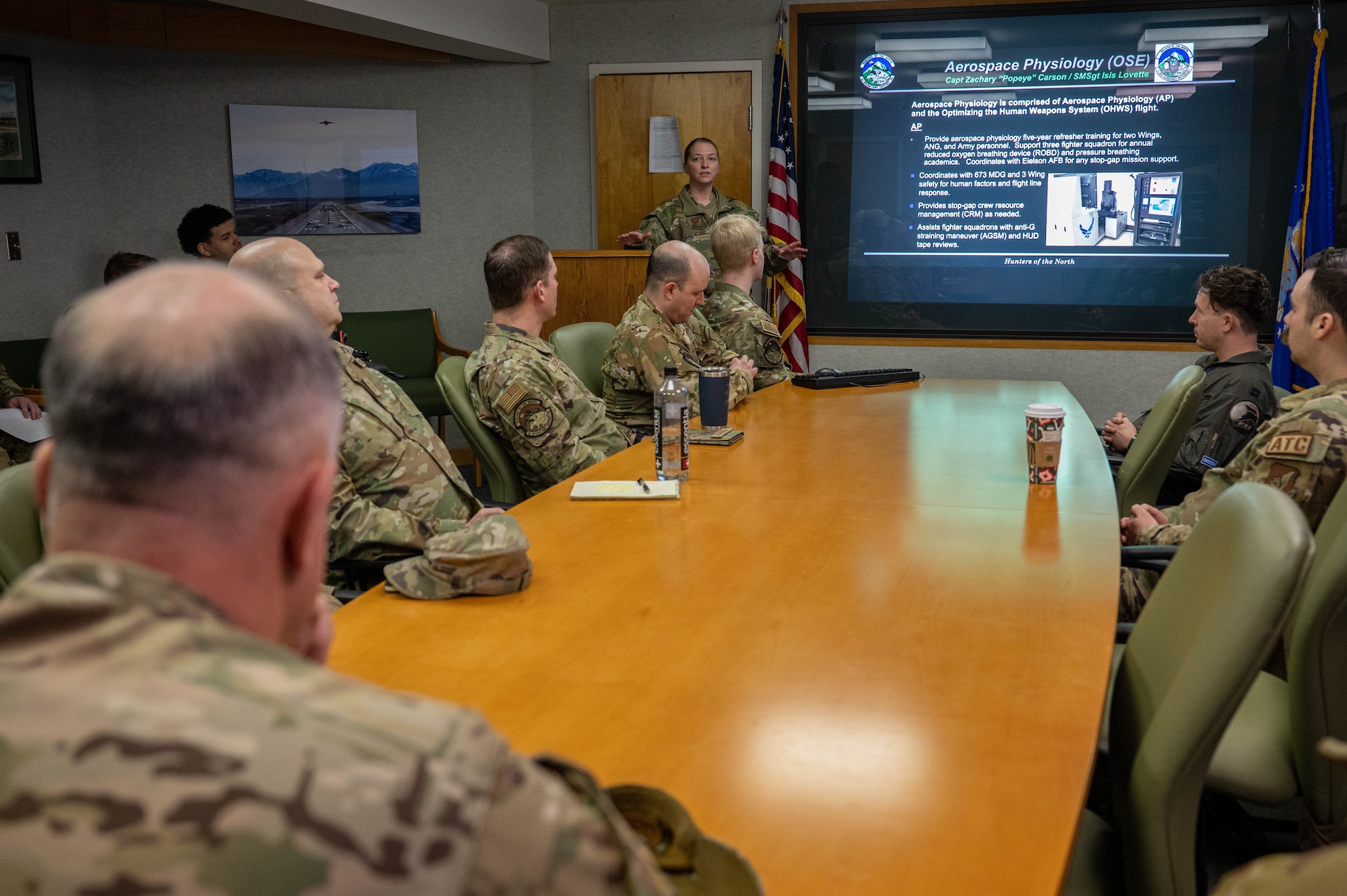 An Airman briefing in a conference room.