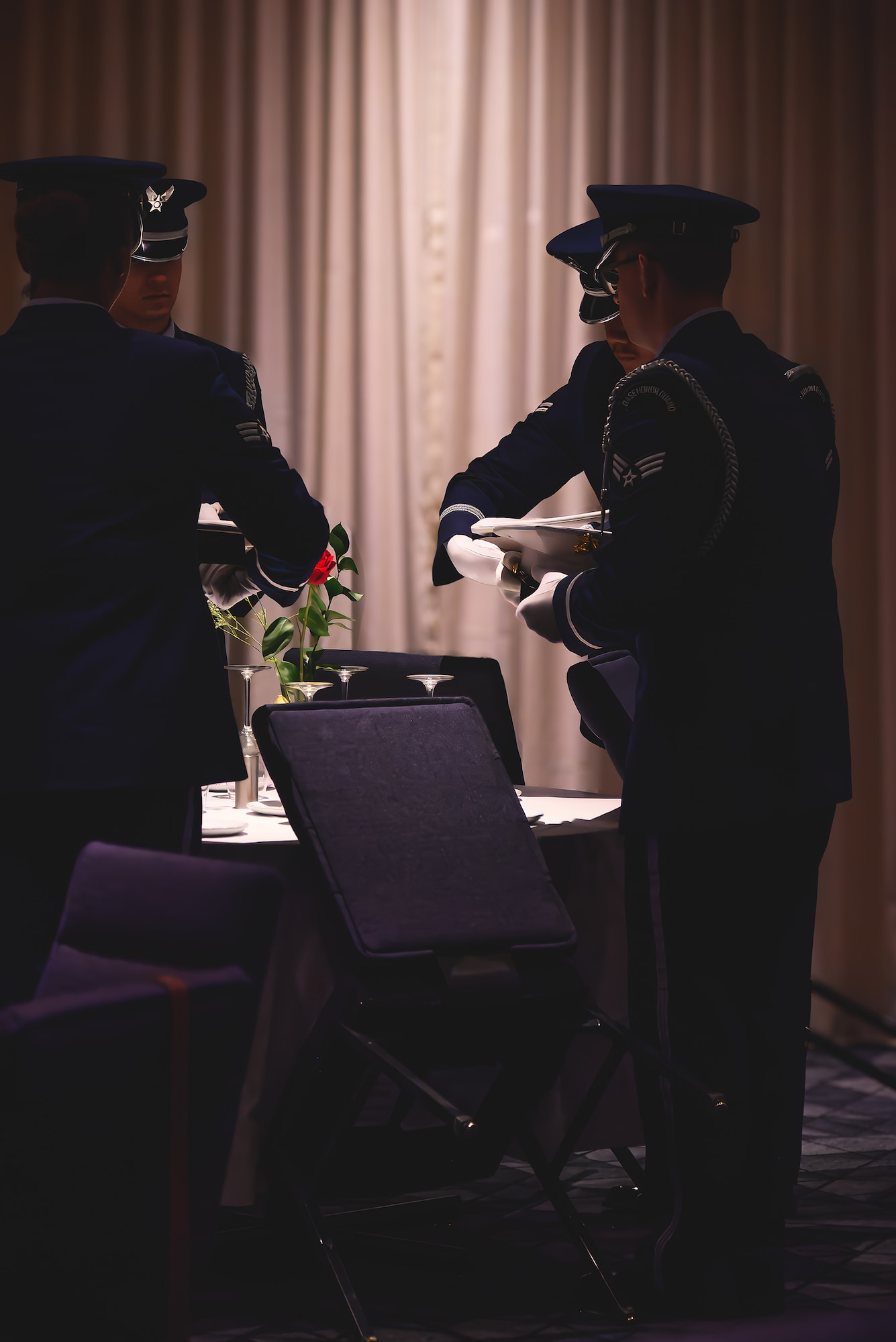 silhouette photo of Honor Guard Airmen performing a recognition ceremony during an awards banquet.