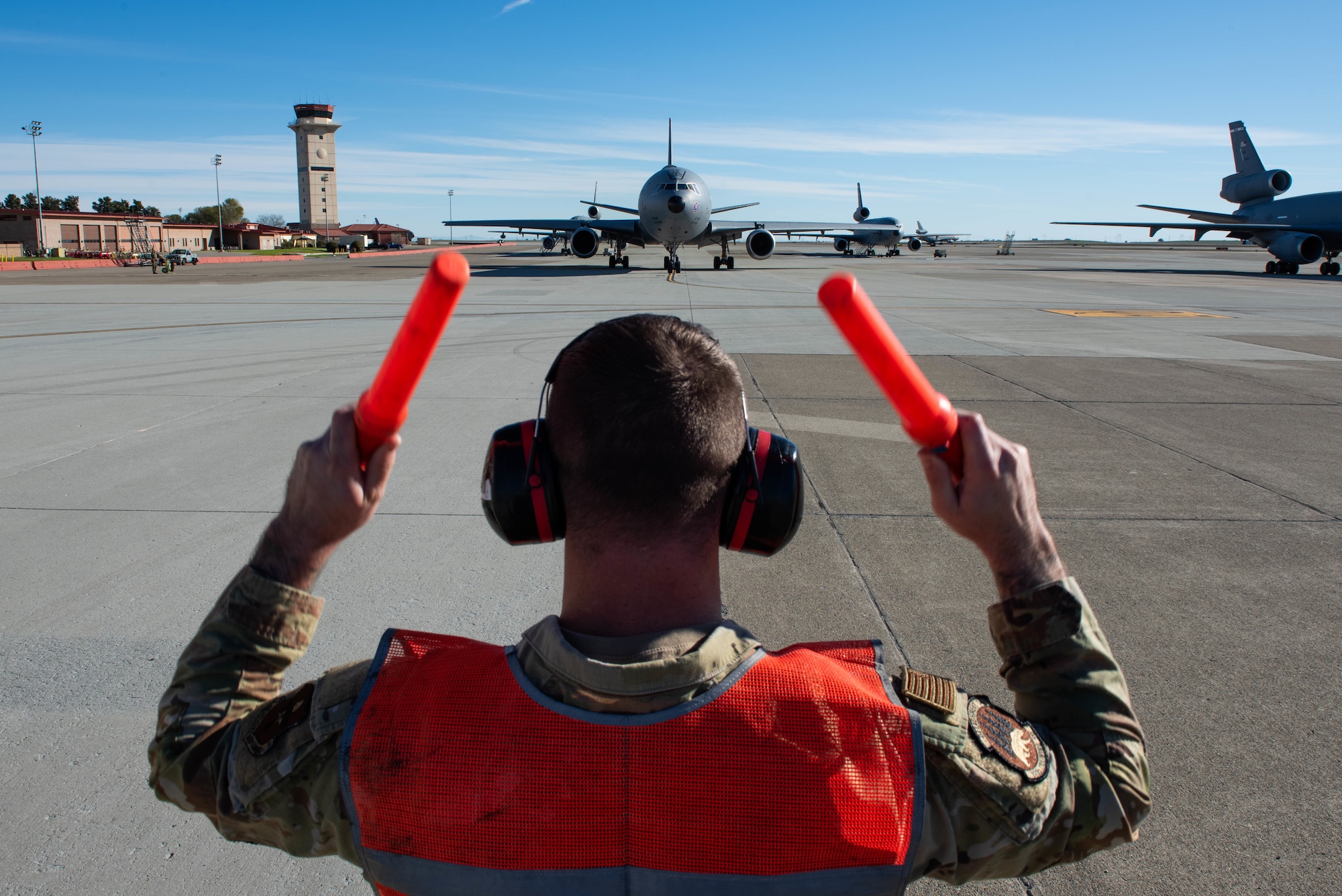 Airman directs aircraft on flight line.