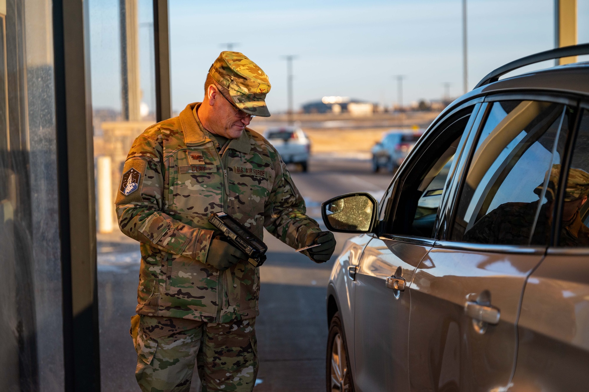 Man stands with scanner in front of vehicle.