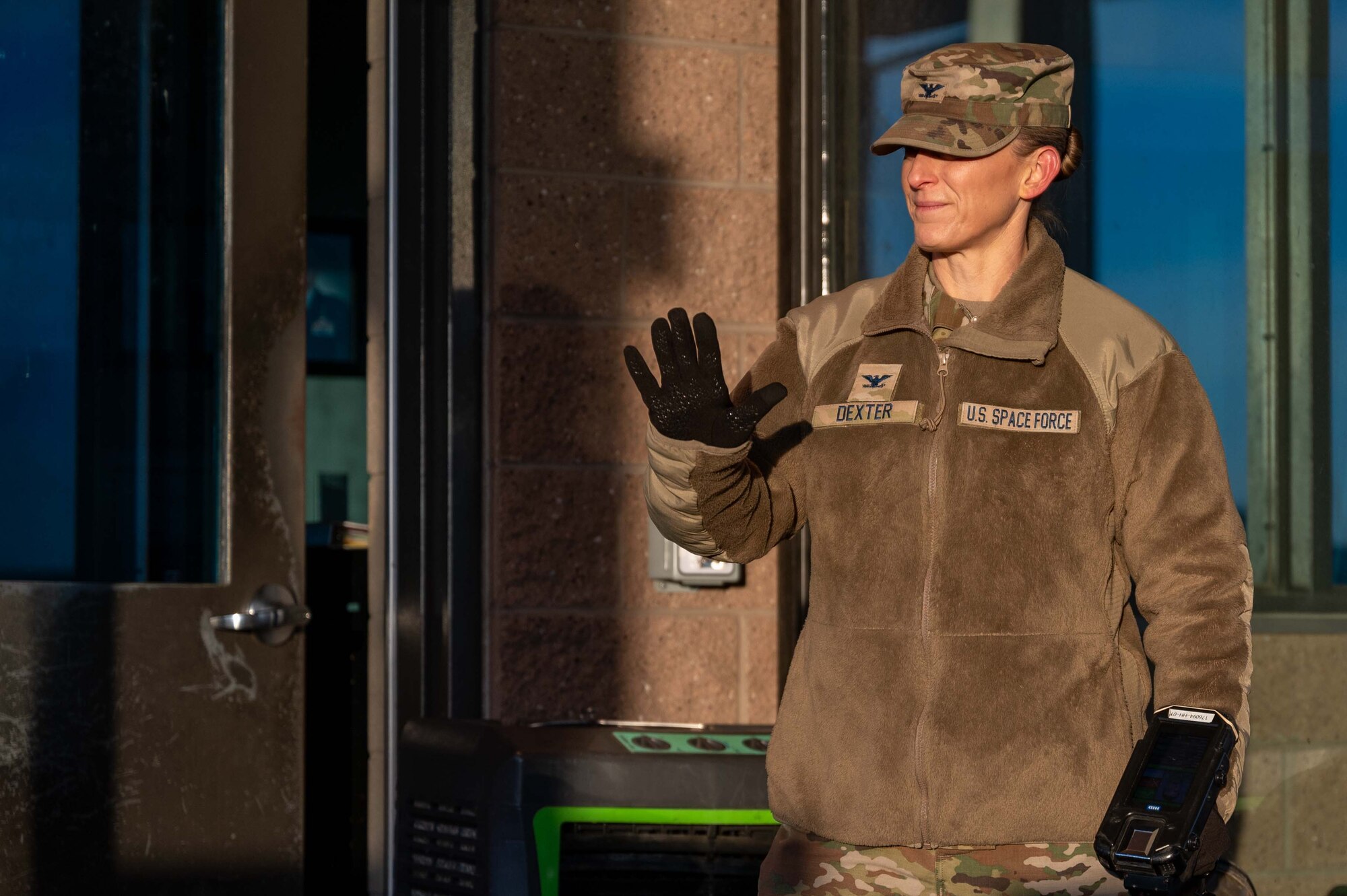 A woman waves while standing.