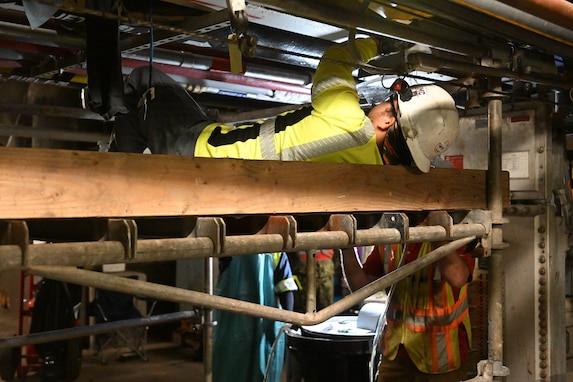 A member in support of Joint Task Force-Red Hill (JTF-RH) secures a drainage line under a spectacle blind to remove residual fuel into a barrel at the Red Hill Bulk Fuel Storage Facility Jan. 18, 2024, Halawa, Hawaii.