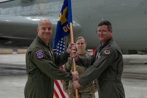 Airmen pass a guidon during an assumption-of-command ceremony.