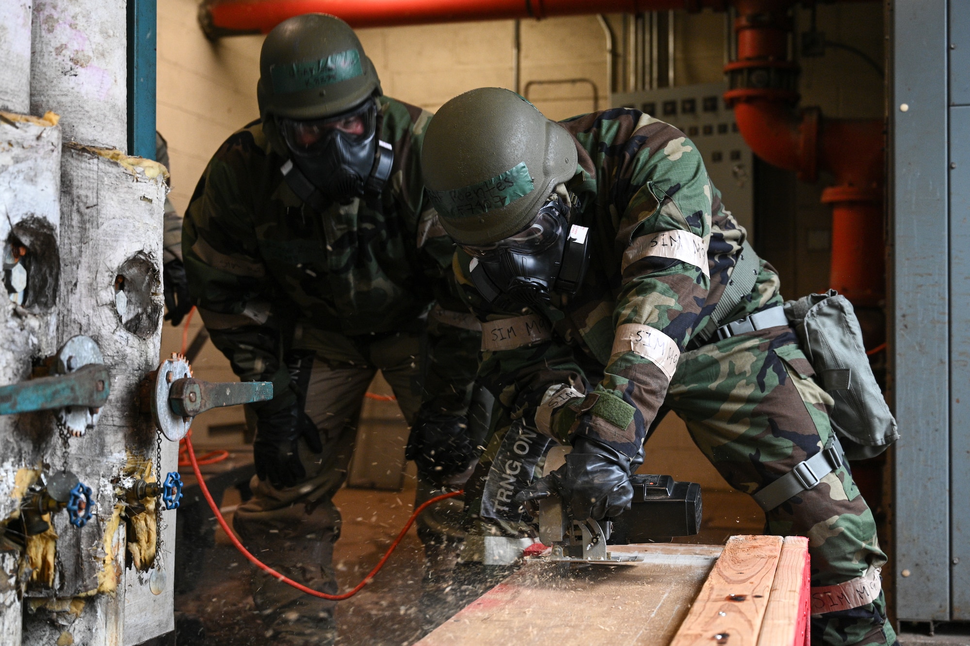 Maryland Air National Guard Staff Sgt. Jesse Koch, assigned to the 175th Civil Engineering squadron, supervises Senior Airman Marcos Fuentes-Martinez, 175th Civil Engineering squadron, as he cuts into a box during Operation Frosty Strike at Martin State Air National Guard Base, Middle River, Maryland, Dec. 1, 2023.